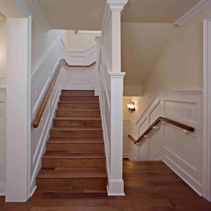  The staircase to the upstairs and to the basement is richly detailed with painted chair railing, hand rail supports, and wainscoting that beautifully contrasts with the wood stairs. The stair treds are finished with fluted edging. 