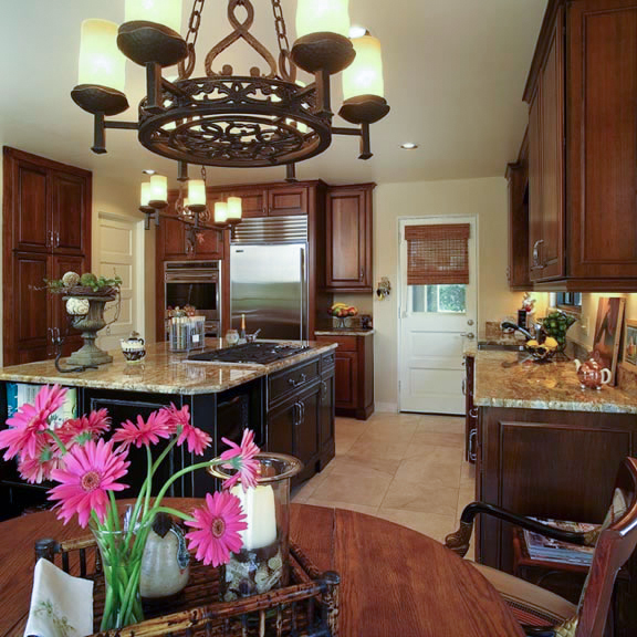 An oversized island is a stunning focal point with a solid slab of granite. Because of the weight, island countertops of this size typically are made from two pieces. The Payors insisted on a single slab to avoid seams. Set on top of black painted cabinets with a rub-through finish, the 800 pound granite countertop also complements the cherry cabinets that line the perimeter of the kitchen.